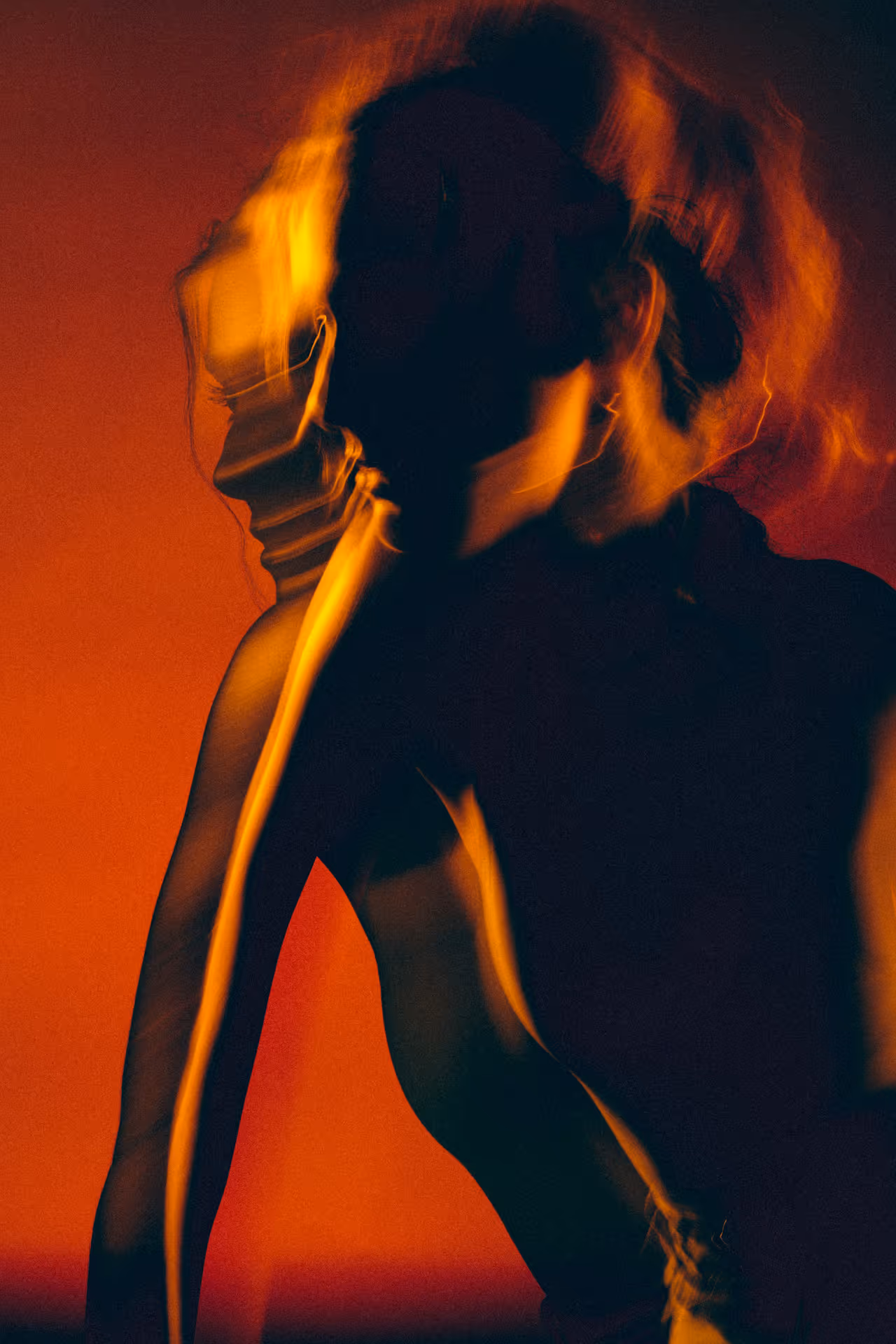 A double-exposure photo of a woman's silhouette, red background